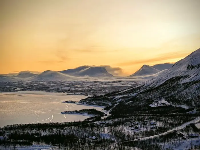 Blick aus winterliche Wälder, See und Berge bei Sonnenuntergang