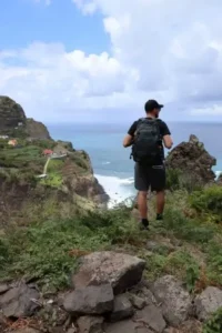 Mann mit Rucksack steht an einer Steilküste