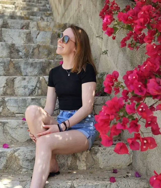 startseite_steffi-1 Steffi auf einer Steintreppe sitzend, im Vordergrund Blumen