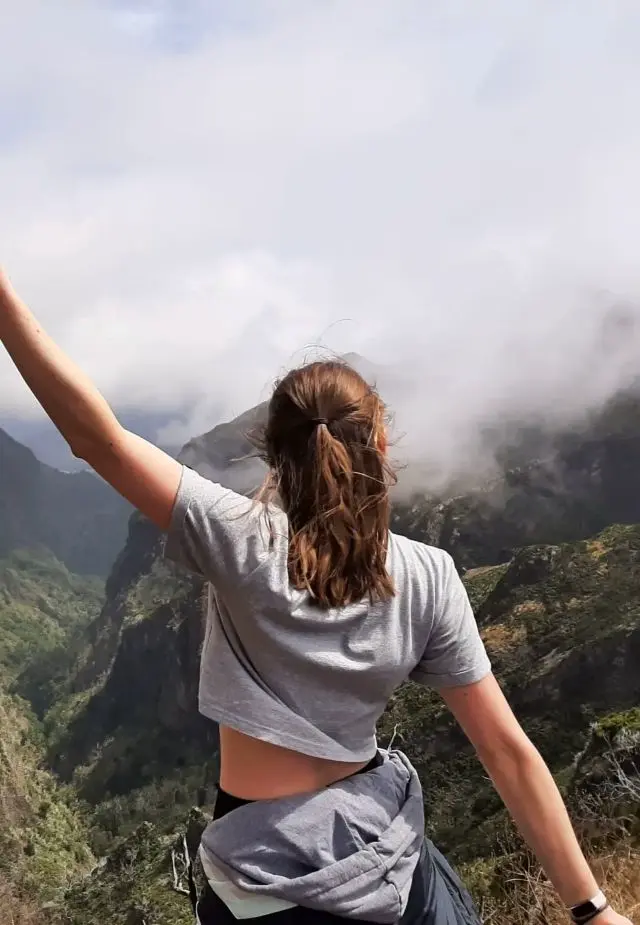 Steffi mit ausgebreiteten Armen vor einer Bergkulisse